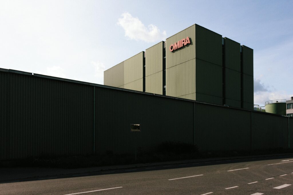 A modern industrial building with a large metal facade under a clear sky.